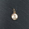 Gold pendant with a symbol on a black background