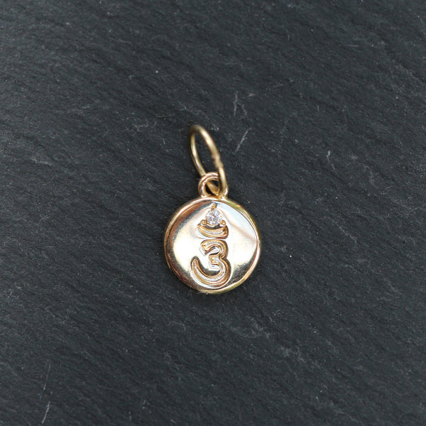 Gold pendant with a symbol on a black background
